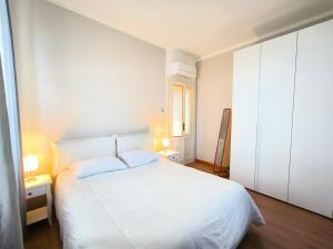 Un dormitorio blanco con una cama blanca y una ventana en LA CASA GIALLA en Baveno