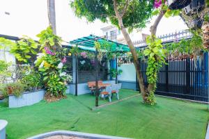 ブンタウにある433 Villa Hồ Bơi Gần Biển Bãi Sau - Free Karaokeのベンチとテーブルと木々のある庭園