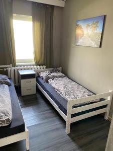 1 dormitorio con 2 camas y ventana en M&R Hostel, en Rostock