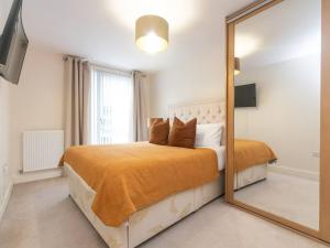 Schlafzimmer mit einem großen Spiegel vor einem Bett in der Unterkunft Pass the Keys Modern 2 bedroom and 2 Bath Apartment in London in Edgware