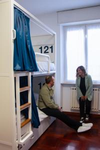 a man and a woman sitting in a bunk bed at Bovisa Urban Garden in Milan