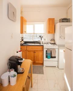 a kitchen with wooden cabinets and a white stove top oven at Cozy 1Bed, 1Bath in Brookline, MBTA in Brookline