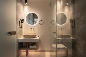 a bathroom with two sinks and a shower with a mirror at Manili Boutique Suites & Villas in Archanes