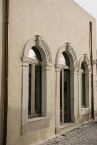 Manili Boutique Suites & Villas في أرتشانيس: نافذتين مقوستين على جانب المبنى