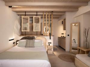 um quarto com uma grande cama branca e um espelho em Manili Boutique Suites & Villas em Archanes