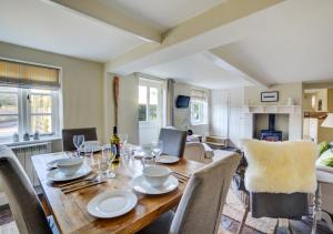 a dining room with a wooden table and chairs at Rose Cottage in Sedgeford
