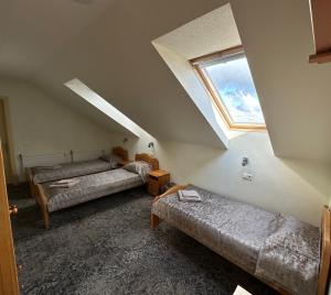 a attic room with two beds and a window at Keta in Marijampolė