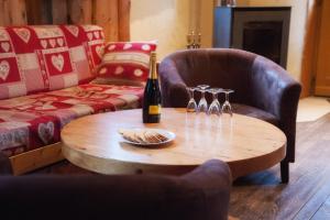 a living room with a table with a bottle of champagne at La Tanière des copains in La Bresse