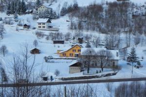 un pueblo en la nieve con casas y árboles en La Tanière des copains en La Bresse