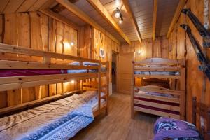 a room with two bunk beds in a cabin at La Tanière des copains in La Bresse