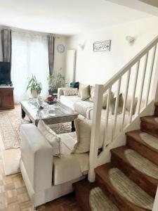 a living room with a couch and a table at Villa charmante à Élancourt avec jardin privé in Élancourt