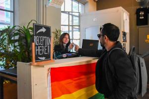 un homme debout à un bureau avec un drapeau arc-en-ciel dans l'établissement Bovisa Urban Garden, à Milan