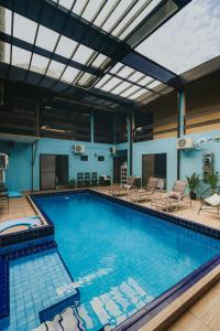 a large swimming pool with lounge chairs at Pousada Cidreira in Morretes