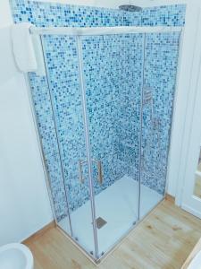 y baño con ducha y mampara de cristal. en Casa Acquachiara - a due passi dalla spiaggia, en Monte Argentario