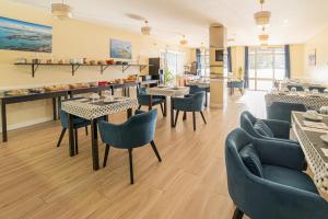 restauracja ze stołami, krzesłami i ladą w obiekcie Hôtel de la Mairie w mieście Saint-Pol-de-Léon