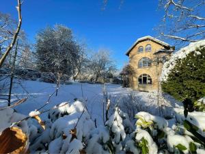 een huis bedekt met sneeuw voor een tuin bij Genval-BNB-Lake in Genval