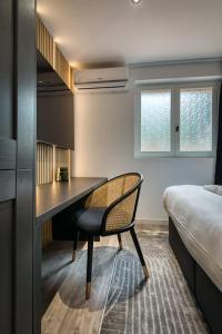 Cette chambre comprend un bureau, un lit et une chaise. dans l'établissement *Love Room : *Pour un séjour en amoureux*, à Sotteville-lès-Rouen