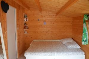a room with a bed in a wooden cabin at La cabane de Robinson à 500m de la plage in Lacanau
