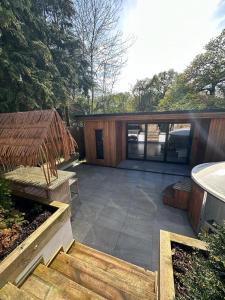 a backyard with a patio and a house at Peaceful retreat with hot tub and sauna in Edgware