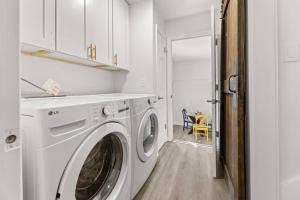 a white washer and dryer in a white laundry room at The Gardenia House in Charleston