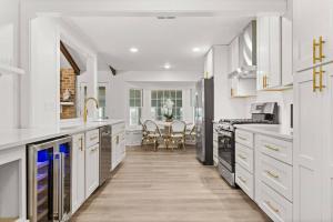 a white kitchen with white cabinets and a table at The Gardenia House in Charleston