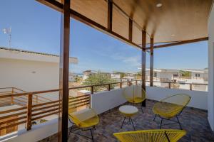 uma varanda com cadeiras e mesas amarelas num edifício em Gran Pacifica Beach Resort & Homes em San Diego