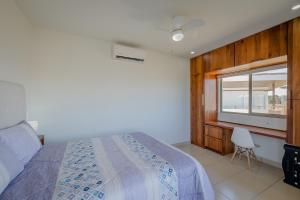 ein Schlafzimmer mit einem Bett, einem Fenster und einem Stuhl in der Unterkunft Gran Pacifica Beach Resort & Homes in San Diego