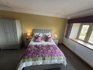 a bedroom with a large bed and two windows at The Manor Boutique Hotel Restaurant and Bar in Conwy