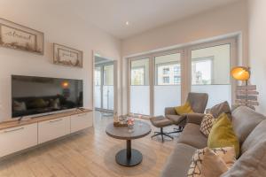a living room with a couch and a tv at Apartment Strandzauber, Am Alten Deich 4-6 Whg 11 in Dangast