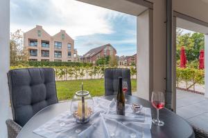 a table with a bottle of wine and two glasses at Apartment Strandzauber, Am Alten Deich 4-6 Whg 11 in Dangast