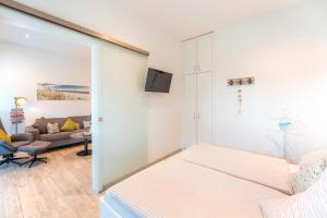 a bedroom with a bed and a living room at Apartment Strandzauber, Am Alten Deich 4-6 Whg 11 in Dangast