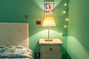 Un dormitorio con una cama y una lámpara en una mesita de noche. en Green View Apartment with pool, en Castiglioncello