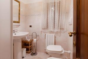 Un baño blanco con inodoro y lavabo. en Green View Apartment with pool, en Castiglioncello 14 fotos más
