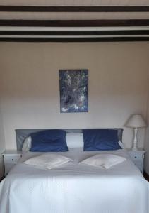 een slaapkamer met een wit bed met blauwe kussens bij LACUSTRA in Chindrieux