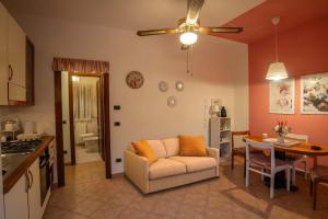 una sala de estar con un sofá y una mesa en Green View Apartment with pool, en Castiglioncello