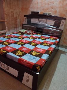 a bed with a quilt on it in a room at Krishna Home Stay in Mathura