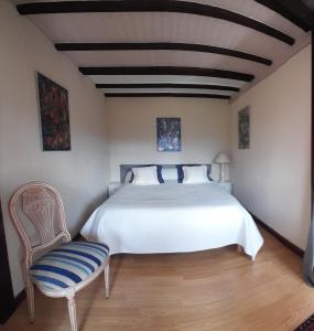 um quarto com uma cama branca e uma cadeira em LACUSTRA em Chindrieux