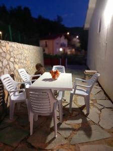 uma mesa branca e cadeiras num pátio à noite em Villa Marinov em Ohrid