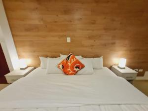 uma grande cama branca com uma almofada laranja em HOTEL CUSCO PERU em Cusco