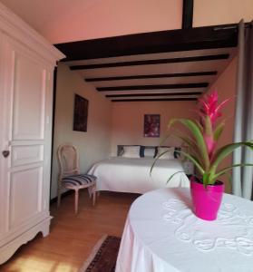 LACUSTRA في Chindrieux: غرفة نوم مع سرير وزرع الفخار على طاولة