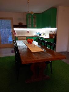 eine Küche mit einem Holztisch und grünen Schränken in der Unterkunft Villa Marinov in Ohrid