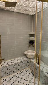 a bathroom with a toilet and a tiled floor at BABIL ANTIQUE HOTEL in Sanlıurfa