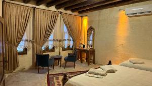 a bedroom with two beds and a desk and windows at BABIL ANTIQUE HOTEL in Sanlıurfa