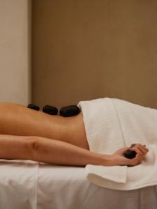 kobieta leżąca na łóżku z ręcznikiem w obiekcie Grand Hotel w Łodzi