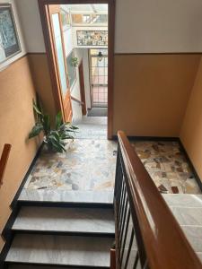 einen Flur mit einer Treppe mit einer Pflanze auf dem Boden in der Unterkunft Hotel La Pineta in Cogoleto