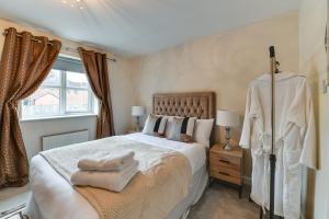 a bedroom with a large bed with towels on it at Charming 2-Bed House in Middleton Manchester in Manchester