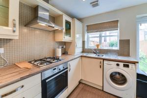 a kitchen with a washing machine and a washer at Charming 2-Bed House in Middleton Manchester in Manchester