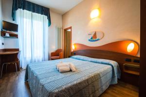 1 dormitorio con 1 cama con 2 toallas en Miramare Hotel Ristorante Convegni, en Cesenatico