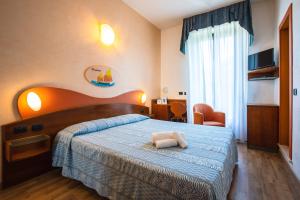 1 dormitorio con 1 cama con edredón azul en Miramare Hotel Ristorante Convegni, en Cesenatico