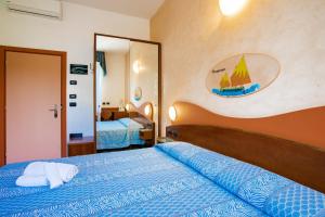 una camera con letto blu e specchio di Miramare Hotel Ristorante Convegni a Cesenatico